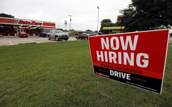 FILE- In this Sept. 27, 2018, file photo a bilingual help wanted sign for Auto Zone is posted outside the store in Canton, Miss.