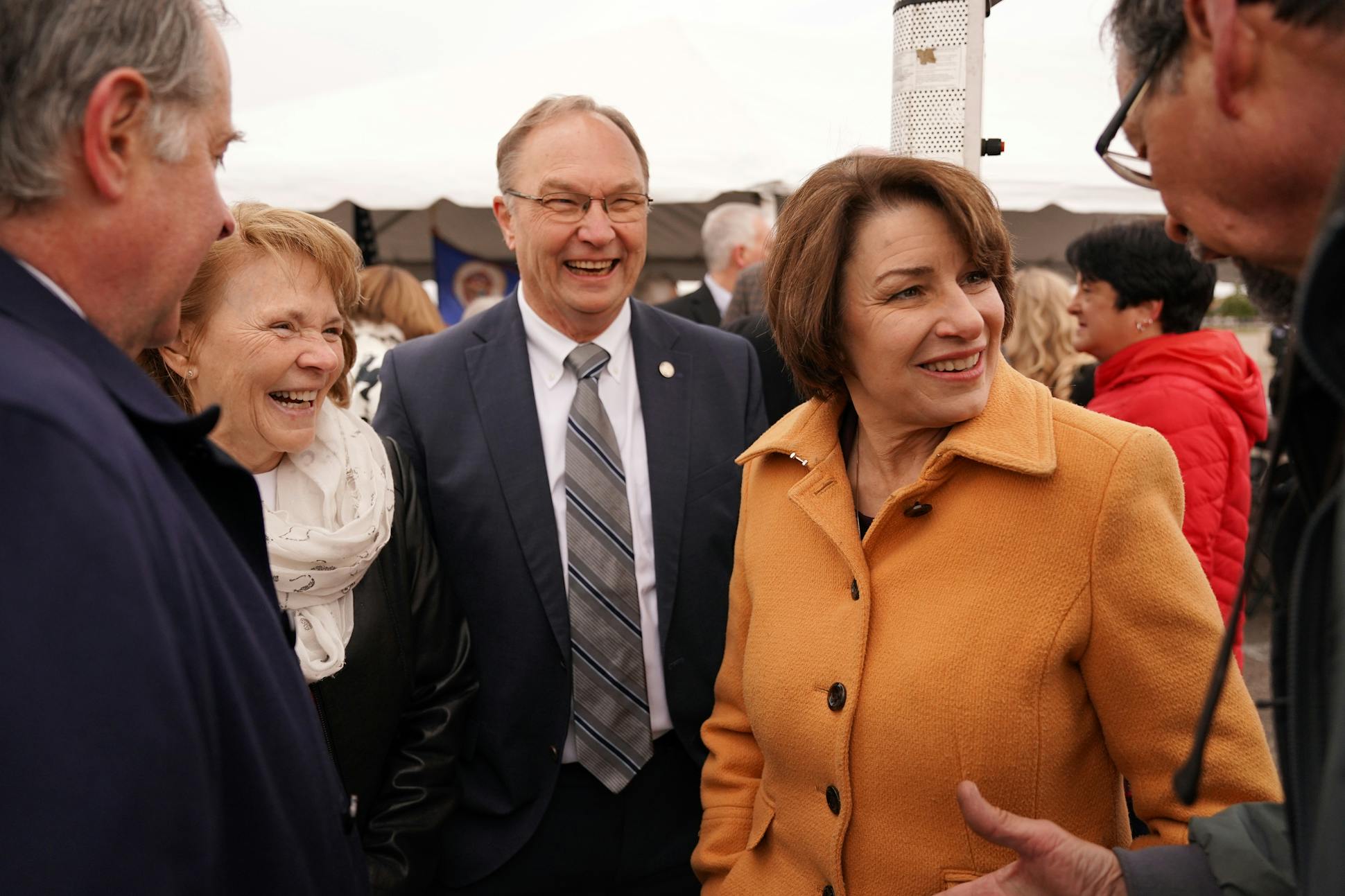 Klobuchar was greeted by supporter Bill Biros, right, as she chatting with other elected officials following the I-94 West Corridor Coalition Groundbreaking Event in Albertville.