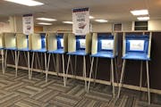 In this Sept. 20, 2018 photo, voting booths stand ready in downtown Minneapolis for the opening of early voting in Minnesota. Election officials and f