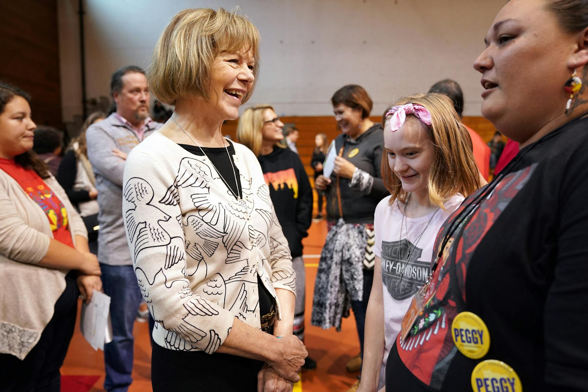 U.S. Sen. Tina Smith spoke with Brooke DeNio, 12, of White Bear Lake and her aunt Mysti Babineau, right, during an Indigenous People's Day Celebration on Oct. 8 at the Minneapolis American Indian Center.