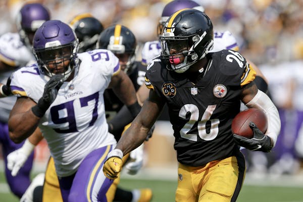 Pittsburgh Steelers running back Le’Veon Bell (26) tries to get away from Minnesota Vikings defensive end Everson Griffen (97) during an NFL footbal