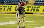 Barnesville coach Bryan Strand embraces juniot tight end/defensive end Hunter Zenzen after Barnesville defeaed Hawley 34-23 in the Section 8, 2A champ
