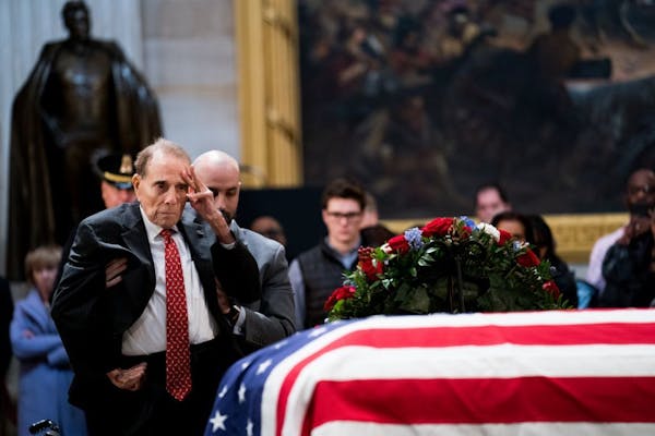 Bob Dole salutes George H.W. Bush's casket
