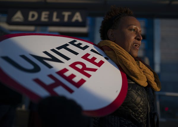Feben Ghilagaber works as a server at a restaurant in the airport marched with other workers during a rally for a $15 minimum wage Wednesday outside T