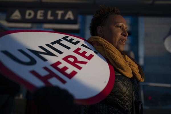 Feben Ghilagaber works as a server at a restaurant in the airport marched with other workers during a rally for a $15 minimum wage Thursday November 2