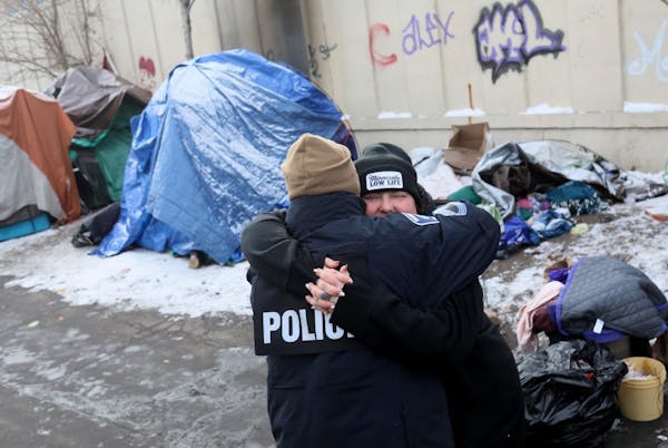Jenny Bjorgo, outreach coordinator for the Minnesota Indian Women’s Resource Center, hugged Minneapolis police Sgt. Grant Snyder as residents began 