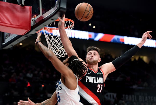 Portland Trail Blazers center Jusuf Nurkic, right, blocks the shot of Minnesota Timberwolves guard Derrick Rose during the first half of an NBA basket