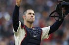 Minnesota Twins' Joe Mauer, the subject of retirement talk, acknowledges a standing ovation as he donned catcher's gear and caught for one pitch again