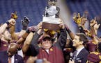 Former Gophers football coach Tracy Claeys raised the winner's trophy after beating Central Michigan 21-14 in the Quick Lane Bowl in 2015.