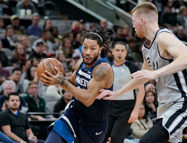 Wolves guard Derrick Rose, left, drove around San Antonio's Davis Bertans during the first half Friday. He sat out the second half.