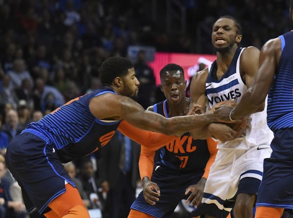 Oklahoma City Thunder forward Paul George, left, tries to get the ball away from Minnesota Timberwolves guard Andrew Wiggins, right, in the first half