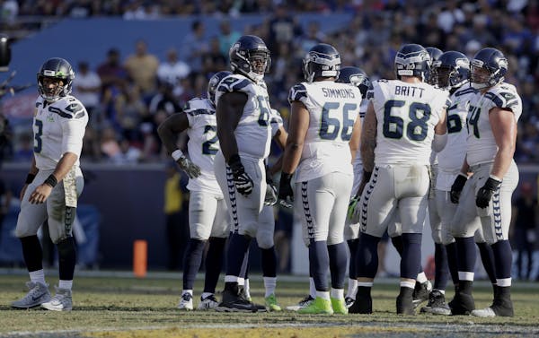Russell Wilson, left, is having one of his best seasons, thanks to a Seahawks offensive line that has given Wilson time and the Seattle offense balanc