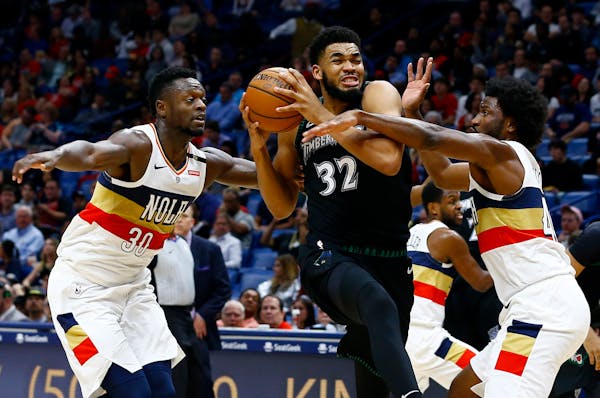 Timberwolves star Karl-Anthony Towns tried to get past New Orleans defenders Julius Randle (30) and Solomon Hill during the first half Monday night.