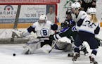 he puck is cleared in front of Blaine goaltender Hailey Hansen in Friday night's game at Fogerty Arena. Hanson stopped 22 shots to help lead the Benga