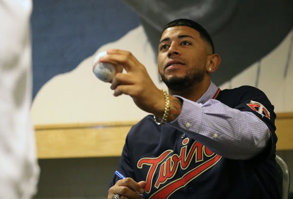 Fernando Romero handed a baseball back to its owner after he autographed it at TwinsFest. He is vying for a starting role, but behind the scenes he is