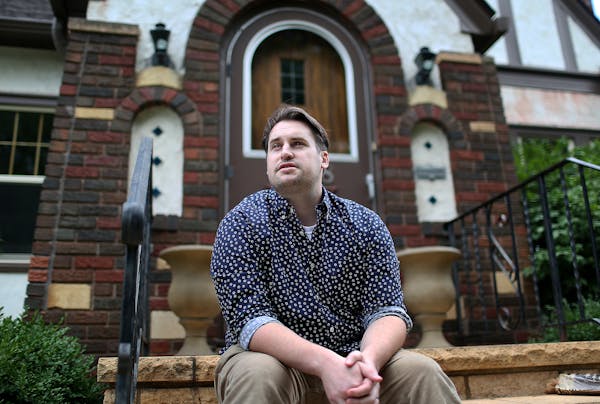 Jade Holman, whose home is subject to a racial covenant, posed in front of his Minneapolis house in 2017.