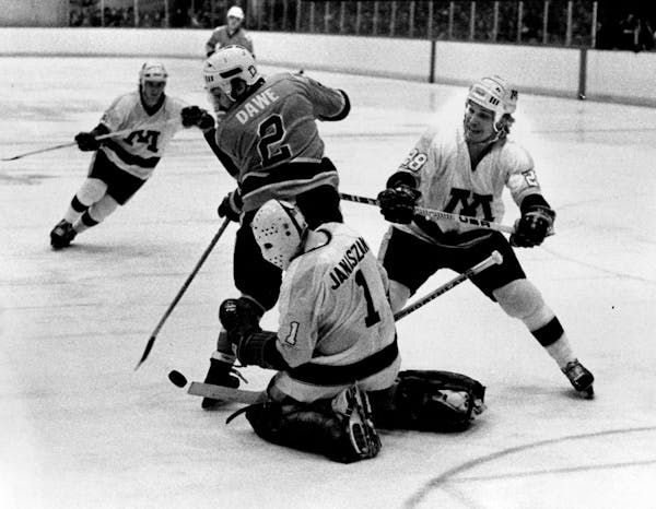 Gophers goalie Steve Janaszak makes a save against Bowling Green on March 19, 1979, as defenseman Mike Greeder (28) swoops in to help.