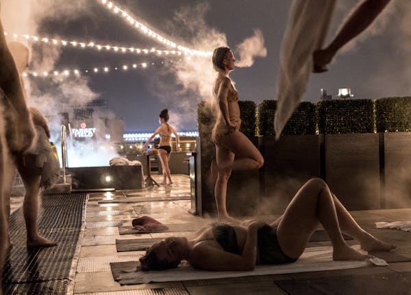 Steam emanated from the bodies of Tricia Sletten, standing center, and others fresh from the sauna during a cool-down on the roof of Minneapolis’ He