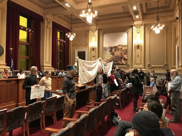 Opponents of the Upper Harbor Terminal redevelopment stood with their backs to the Minneapolis City Council following the unanimous approval of the pr