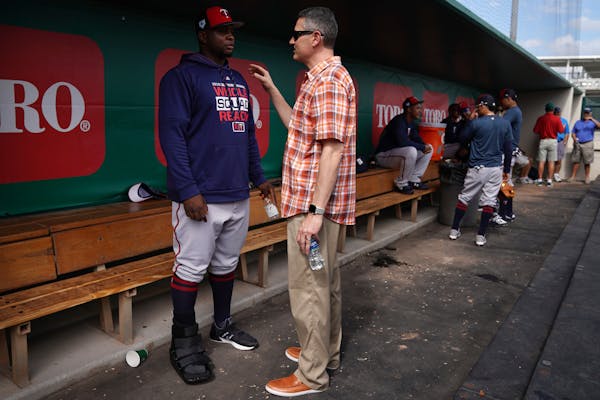 Twins Senior Vice President and General Manager Thad Levine talked with third baseman Miguel Sano, who sat out of drills again Tuesday and wore a prot