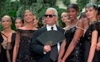 FILE - In this Tuesday July 9, 1996 file photo, Karl Lagerfeld is surrounded by Canadian model Linda Evangelista, left, and British model Naomi Campbe