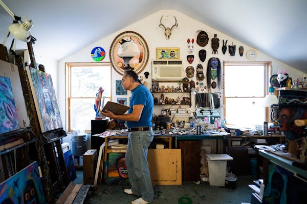 Jim Denomie worked in his home studio, surrounded by his own paintings and a vast collection of masks and trinkets.