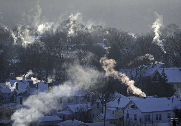 Smoke rises from the chimneys of homes in St. Paul's West 7th neighborhood on Jan. 30, as furnaces tried to keep up with the record-breaking cold last