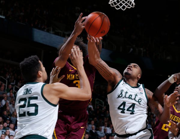 Michigan State's Nick Ward (44) and Kenny Goins (25) and Minnesota's Jordan Murphy, center, vie for a rebound during the first half