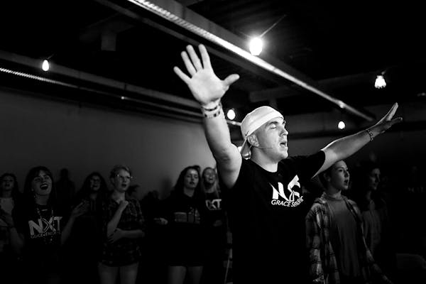 Jake Sullivan, Grace Church's director of student and family ministries, sang and raised his hands in praise during an event in Eden Prairie. Sullivan