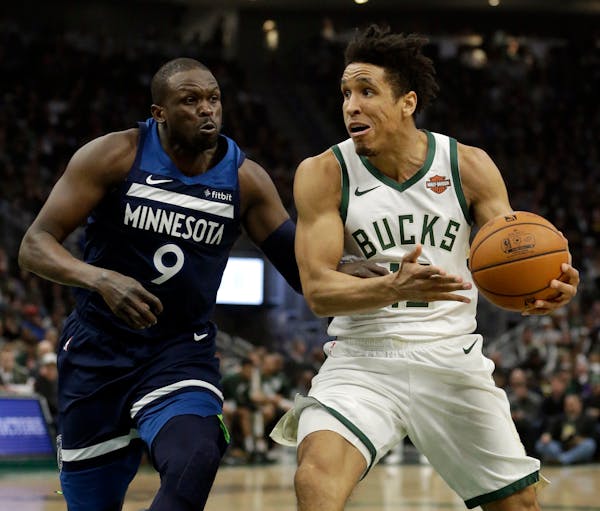 Milwaukee's Malcolm Brogdon, right, went to the basket as defended by Wolves veteran Luol Deng, who has gone from almost never playing to making many 