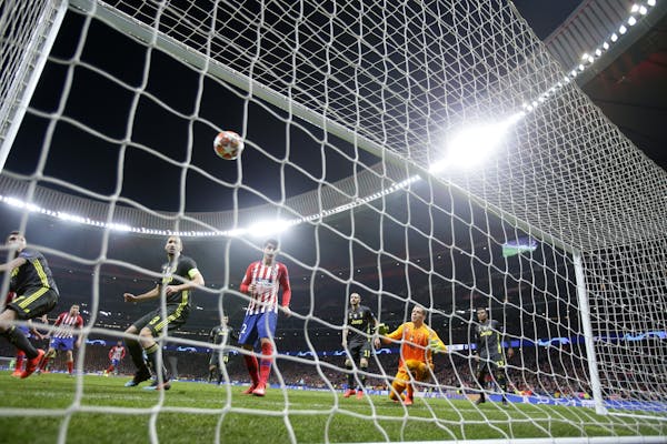 Atletico Jose Gimenez scores his side's opening goal during the Champions League round of 16 first leg soccer match between Atletico Madrid and Juvent