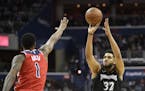 Minnesota Timberwolves center Karl-Anthony Towns (32) shoots against Washington Wizards forward Trevor Ariza (1) during the first half of an NBA baske