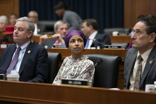 Rep. Ilhan Omar, D-Minn., sits with fellow Democrats David Trone of Maryland, left, and Andy Levin, of Michigan, right, at a session of the House Educ