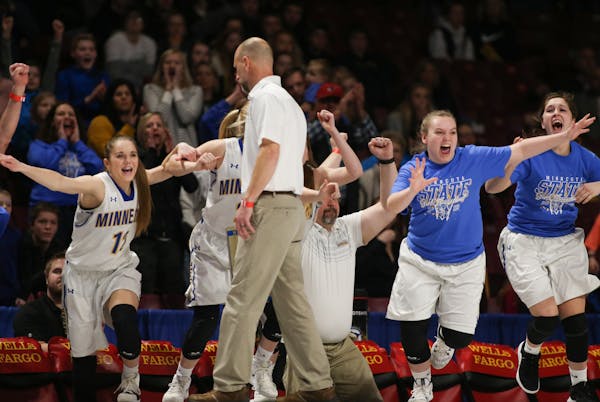The Minneota bench rushed onto the court after Minneota defeated Goodhue 40-31 to win the Class 1A state title on Saturday at Williams Arena. The Viki