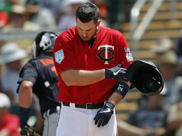 Minnesota Twins first baseman C.J. Cron (24) tosses his helmet after striking out to end the fourth inning of a spring training baseball game against 