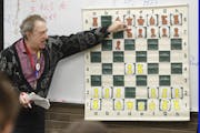 Burnsville Metcalf Middle School chess coach Brian Ribnick shows players a few traps to set up or avoid at the beginning of a game.
