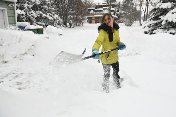 Natasha Cramer, of Robbinsdale, shoveled snow in her driveway after returning home from work Wednesday.