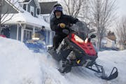 Nick Becchetti drove his snowmobile out of Rob Scheffler’s yard in Anoka, as a group of friends headed down the frozen Rum River to the 201 Tavern &