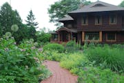 Perennials and grasses shaped by a fieldstone wall and brick pathway feel like they’ve always graced the front entry of the century-old Craftsman.