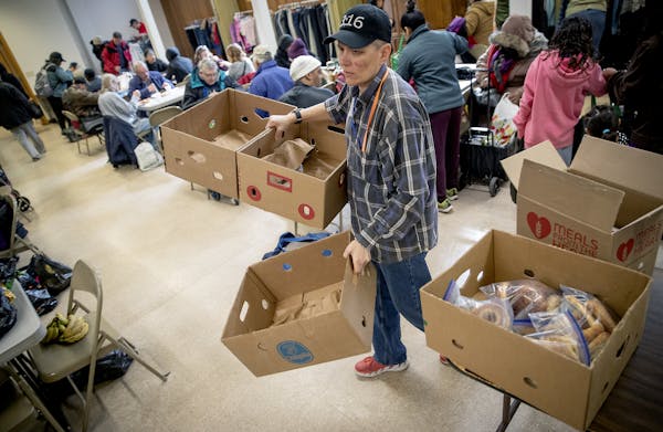 Kay Kuehn, Open Hands Midway executive director, cleared away boxes from a meal the St. Paul organization served Monday to those in need.