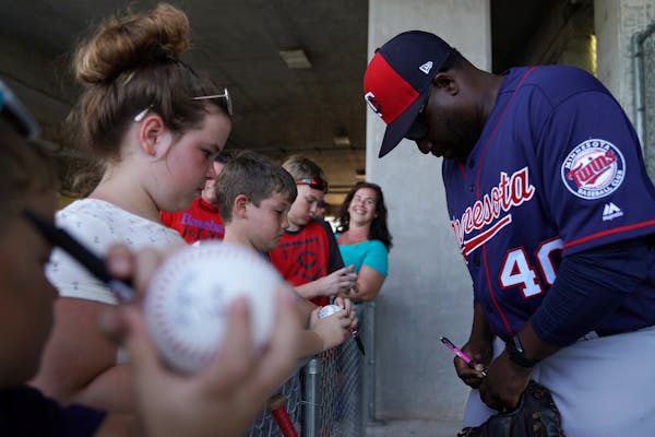 Twins first base coach Tommy Watkins signed autographs in Fort Myers during spring training workouts.