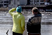 Pedestrians came out to view the flooding at Harriet Island Regional Park and the flowing Mississippi River in St. Paul on Monday afternoon.