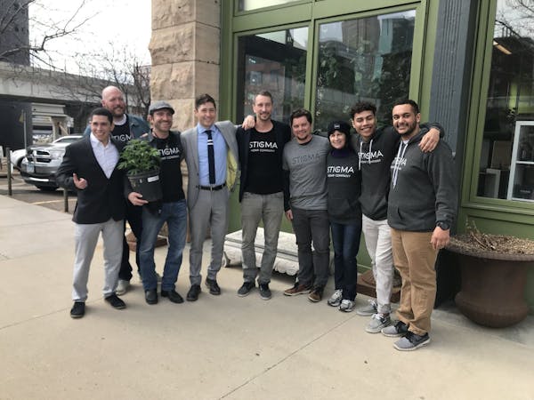 Minneapolis Mayor Jacob Frey, fourth from left, poses with members of the team behind Stigma, a new store selling hemp and CBD products in the North L