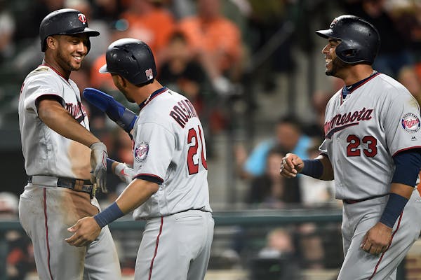Jonathan Schoop, left, is congratulated by Eddie Rosario, center, and Nelson Cruz after hitting a three-run home run against the Orioles in the fourth