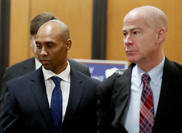 Former Minneapolis police officer Mohamed Noor, center, is accompanied by his attorneys Peter Wold, not pictured, and Thomas Plunkett, right, as he wa