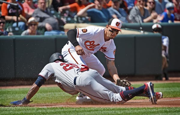 The Minnesota Twins' Byron Buxton, bottom, reached third base ahead of the tag by Baltimore Orioles' Rio Ruiz, top, after tagging up in the fourth inn