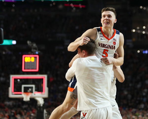 Virginia guard Kyle Guy was lifted off the floor by teammates after he made three free throws to win the game for the Cavaliers.