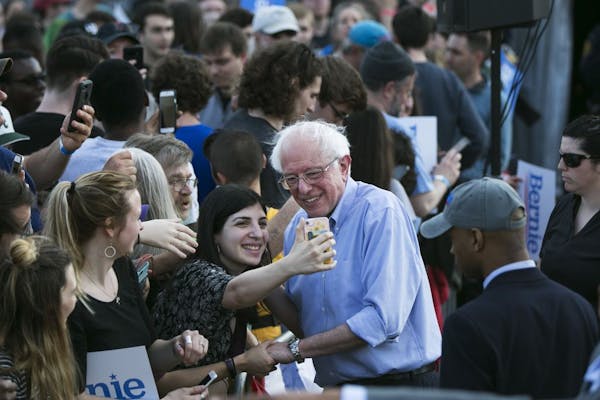Sen. Bernie Sanders (I-Vt.), a candi­date for the Democratic presidenti­al nomin­ation, takes a photo with a fan after speaking at a rally in Pitts