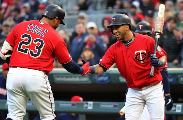 Nelson Cruz is greeted by teammate Eddie Rosario after hitting a solo homer during the first inning