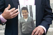 FILE -- Michael DeRoche held a photo of himself at the age of 9 or 10 — the age he was when he says he was abused by a priest in Proctor, Minn.